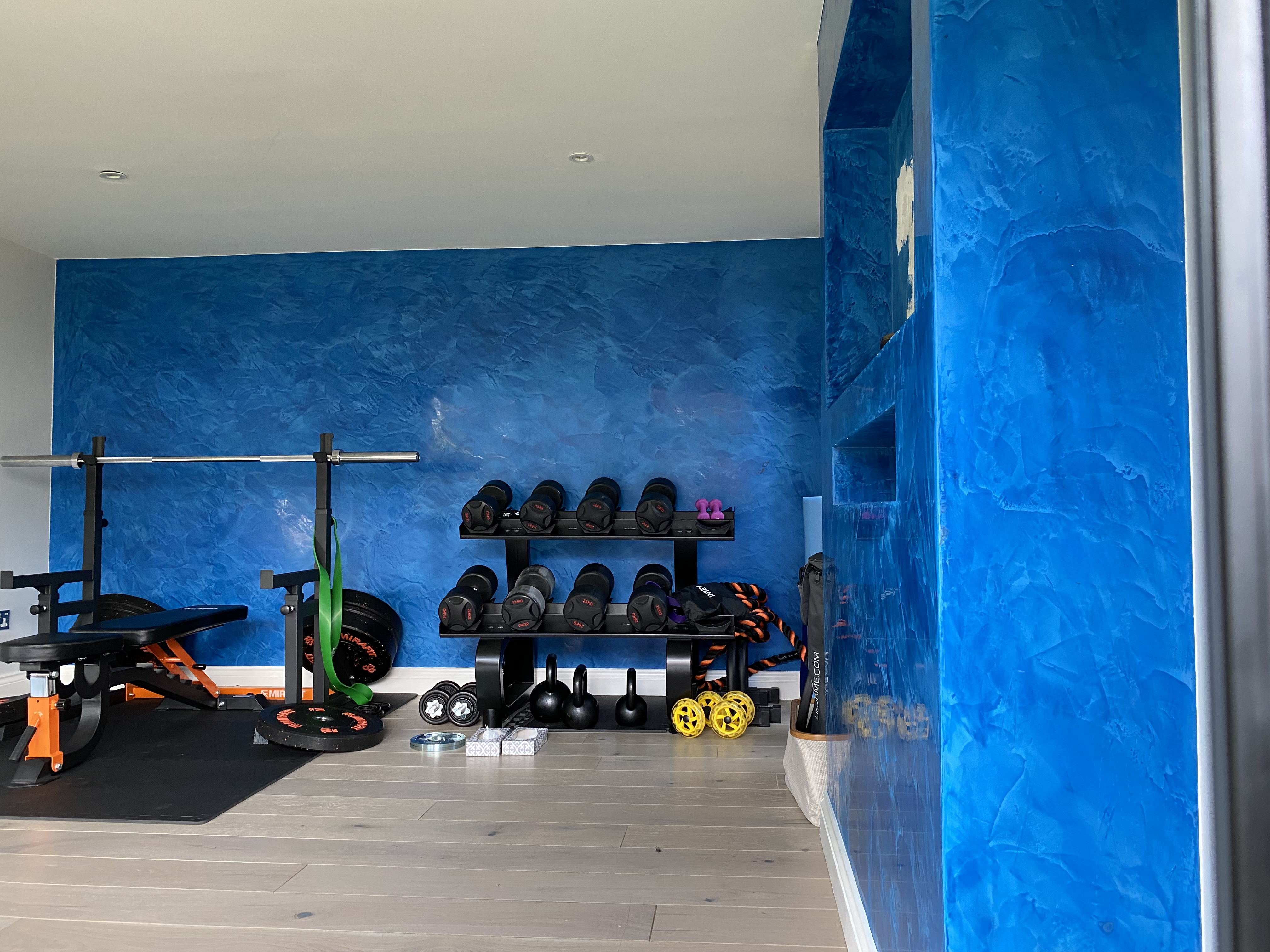 blue venetian polsihed plaster media unit and feature wall in home gym garden studio high barnet london