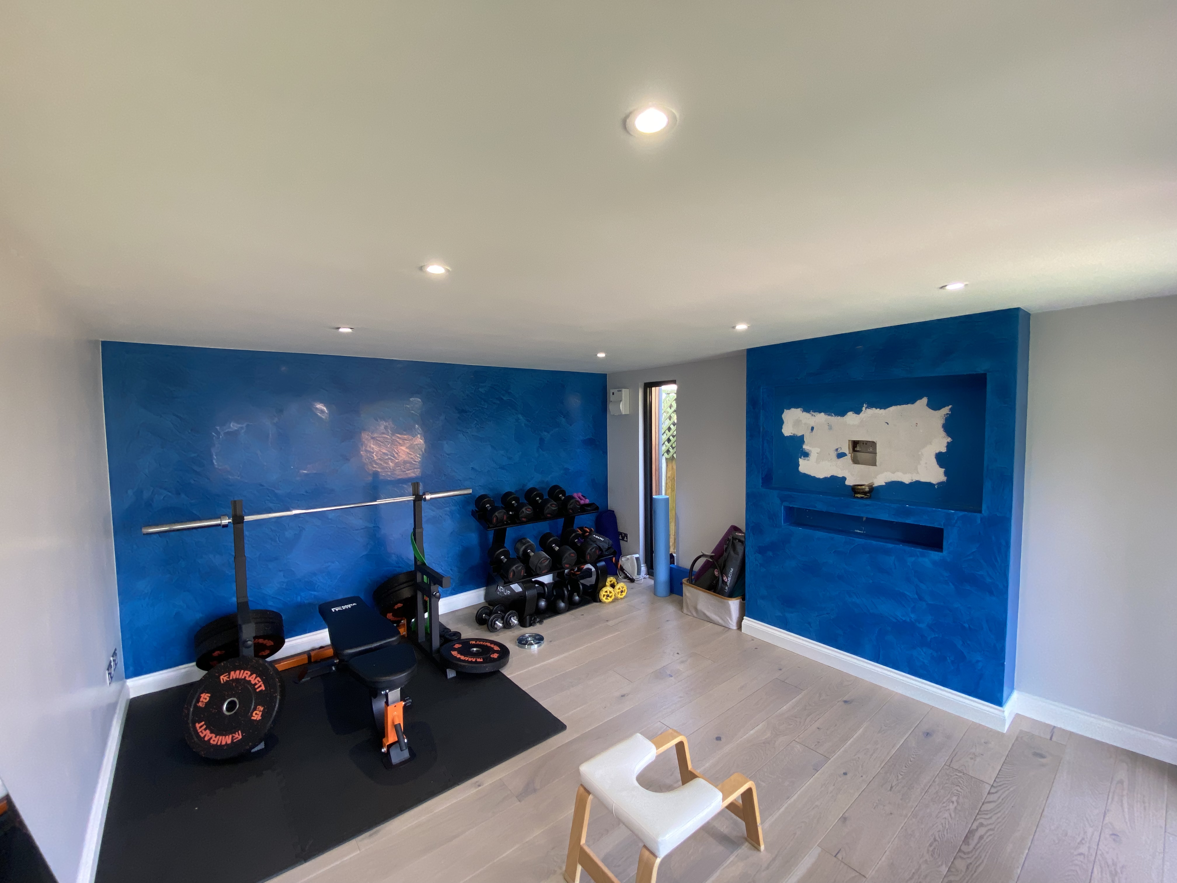 home gym and yoga studio with blue venetian polished plaster feature wall